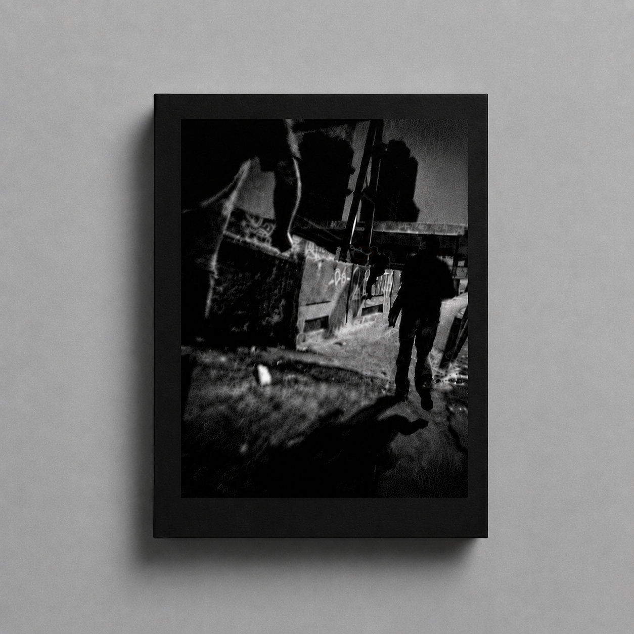 BACKFLASHES remastered 2026: the black book with a black-and-white photograph tipped in on the front